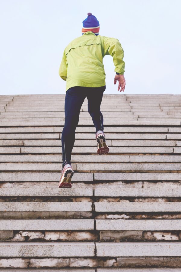 a man running up stairs, doing everything he can to keep moving forward and staying active