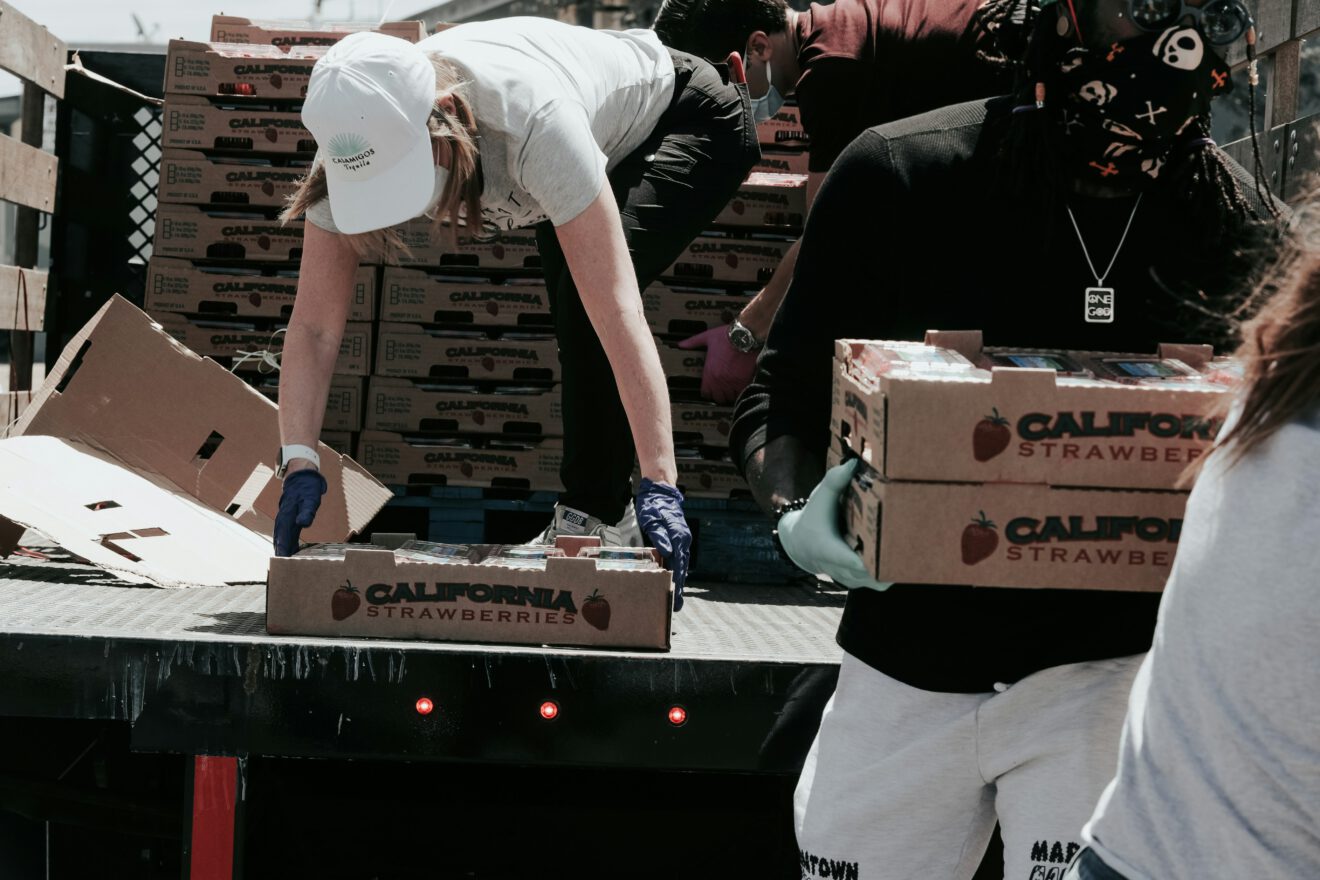 two people unloading a truck and doing some acts of service and helping others