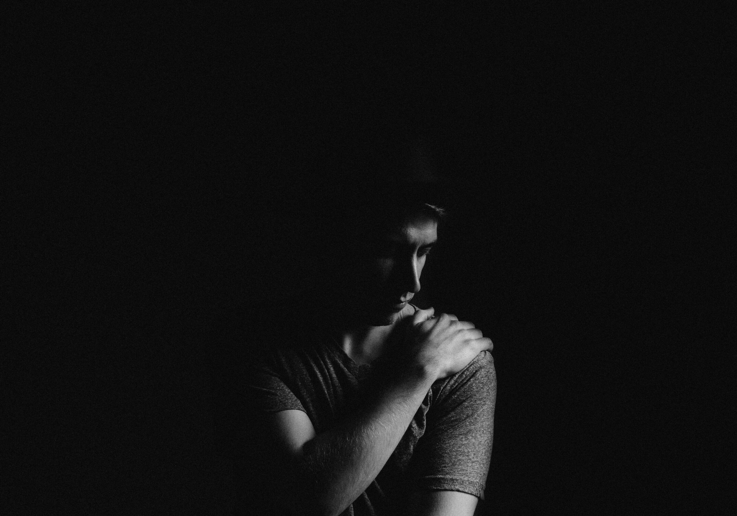 a man sitting alone looking deeply saddened