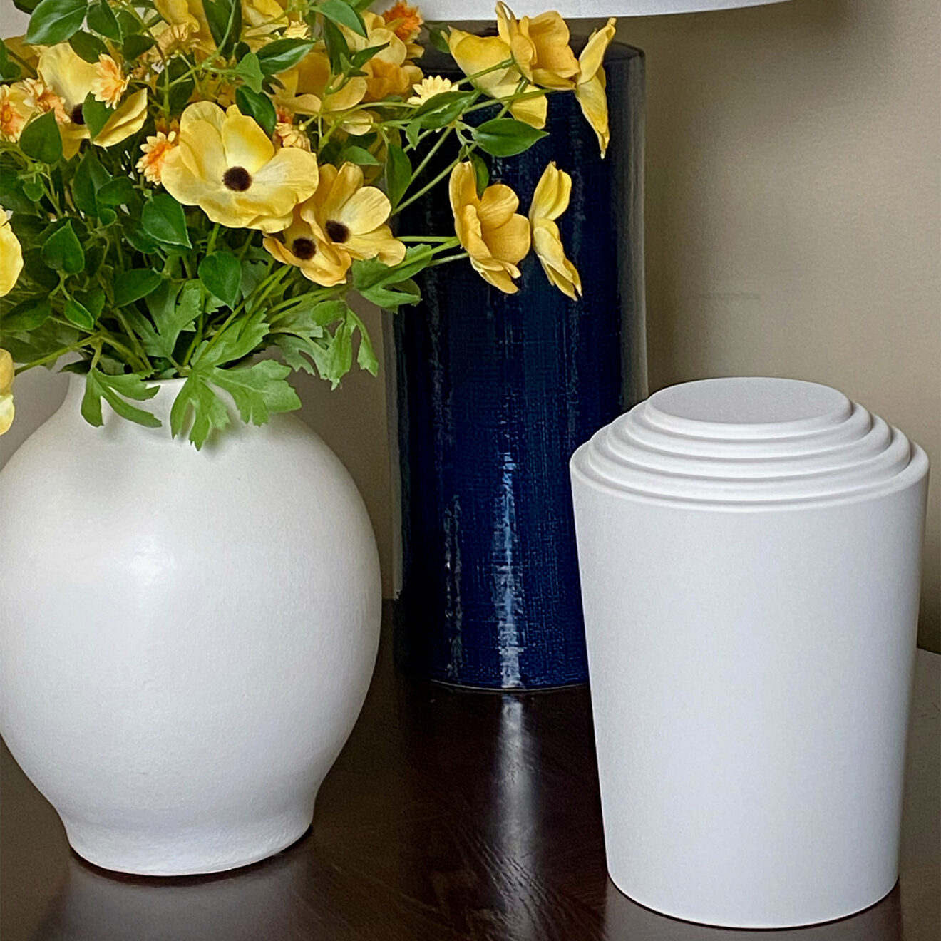 timeless series cremation urn sitting by some flowers and a vase