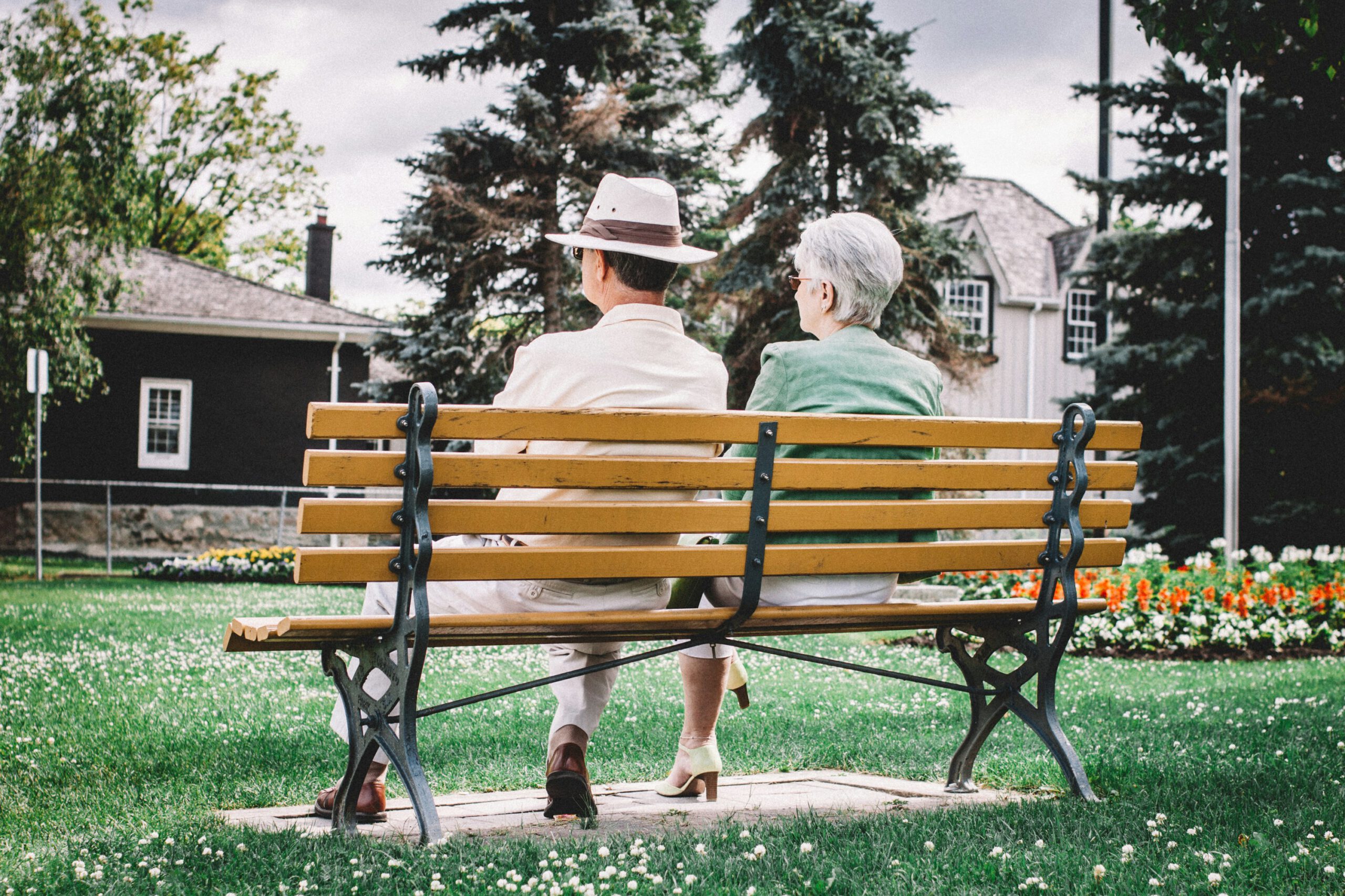 two elderly people sitting on a park bench for our losing a parent blog post