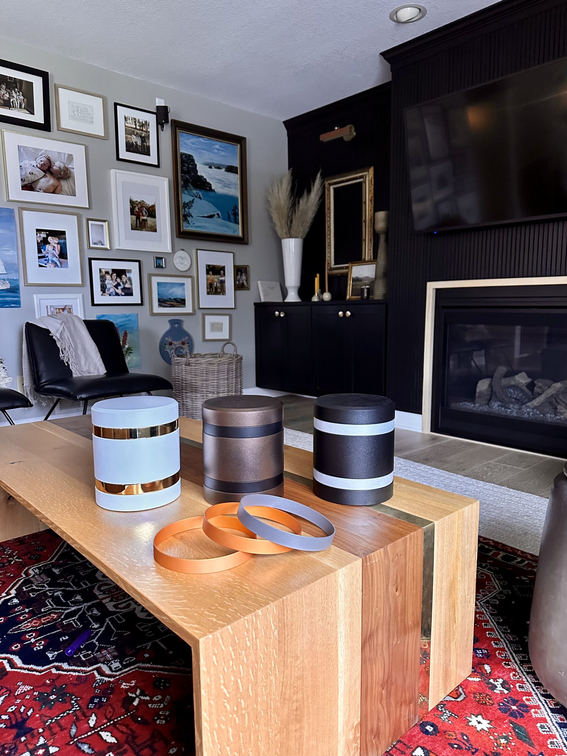 infinite series modern cremation urns displayed on a living room table showing the different bands that can be swapped out to customize the urns (cremation urn sizing guide 2024)