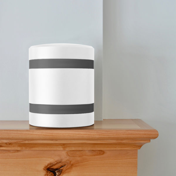 a white metal infinite series modern cremation urn with charcoal bands sitting on a mantel.