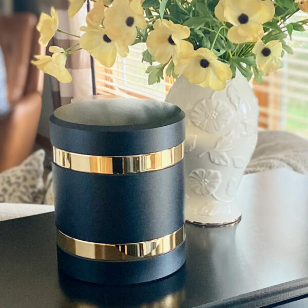 a infinite series cremation urn on a stand in a living room next to some flowers